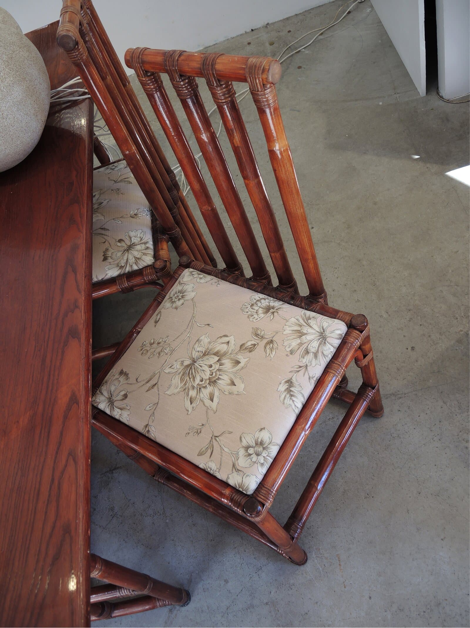A bamboo chair with a floral cushion